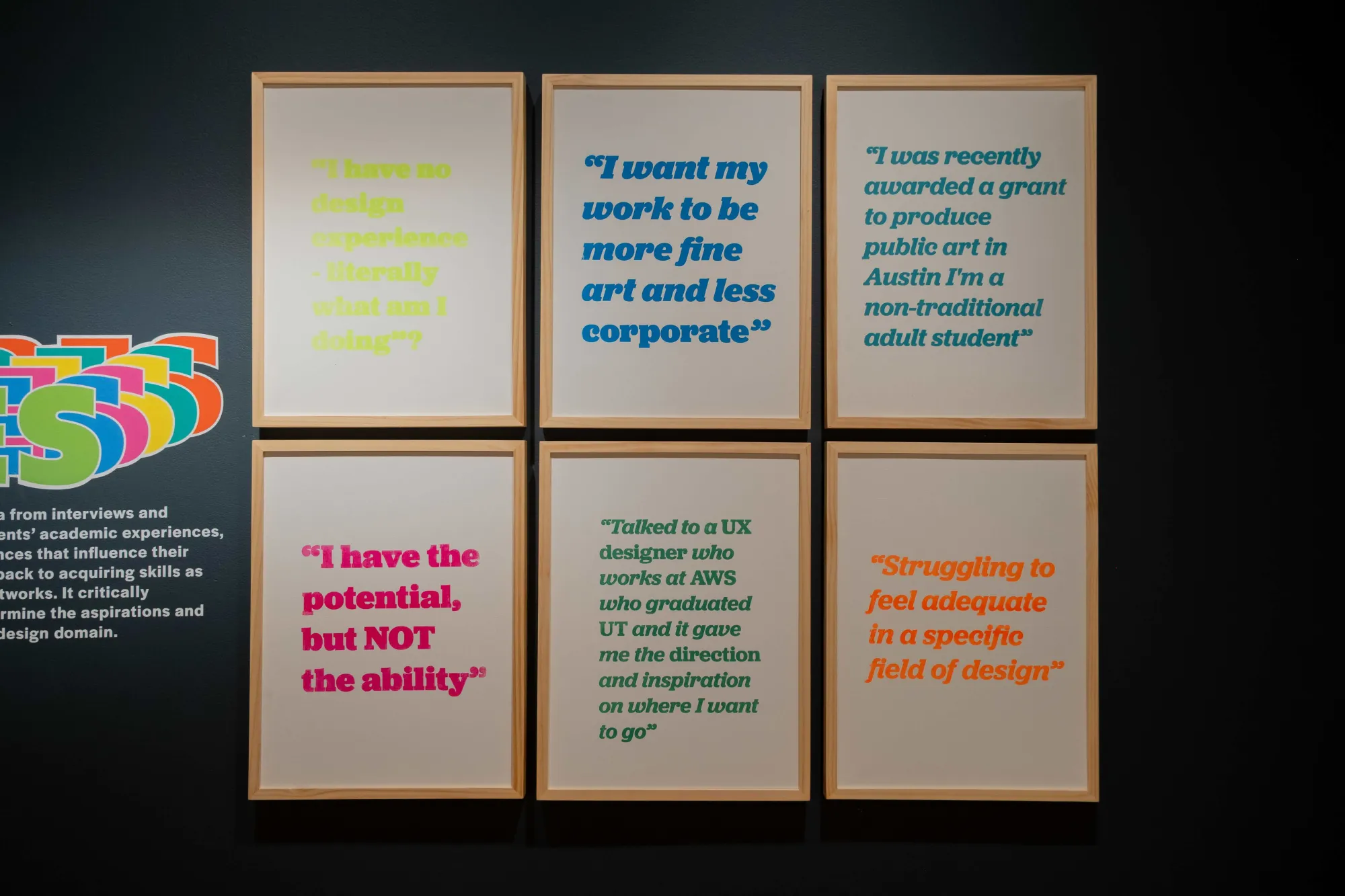Six framed typographic posters displayed in a grid at a design exhibition, each featuring a colorful student quote about design education experiences and aspirations.