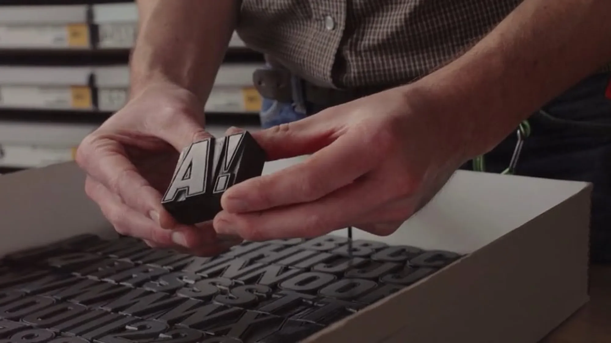 Hands holding antique letterpress blocks